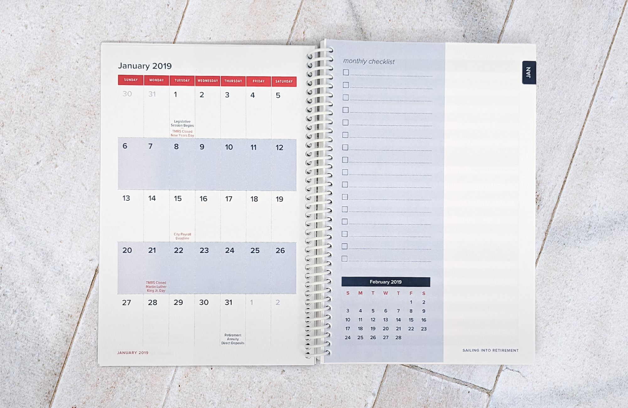 A coil-bound planner opened up to a spread that displays the month of January 2019 on the left hand side and a blank monthly checklist on the right.