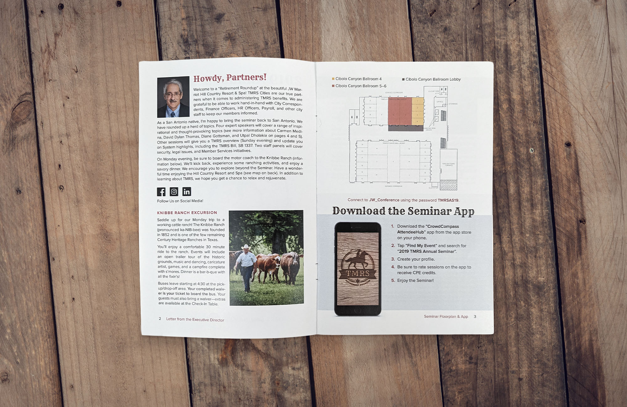 A booklet sits on a wooden surface. It is open to a spread that includes an introduction from David Gavia, details about Knibbe Ranch, a floor plan of the hotel, and instruction on how to download the event app.