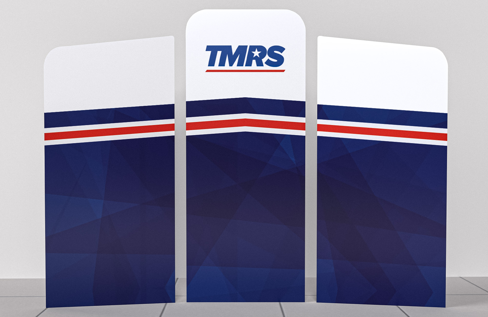 A full view of a booth that displays in three parts. The middle panel is the tallest and displays the TMRS logo at the top. The two side panels are slightly shorter. Across all three panels is a dark blue angular pattern.